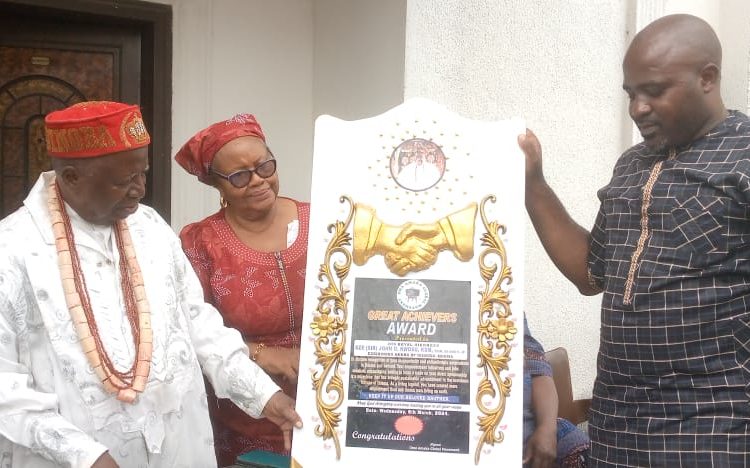 HRH Eze John Nwosu(left) flanked by wife being presented with merit award,recently.